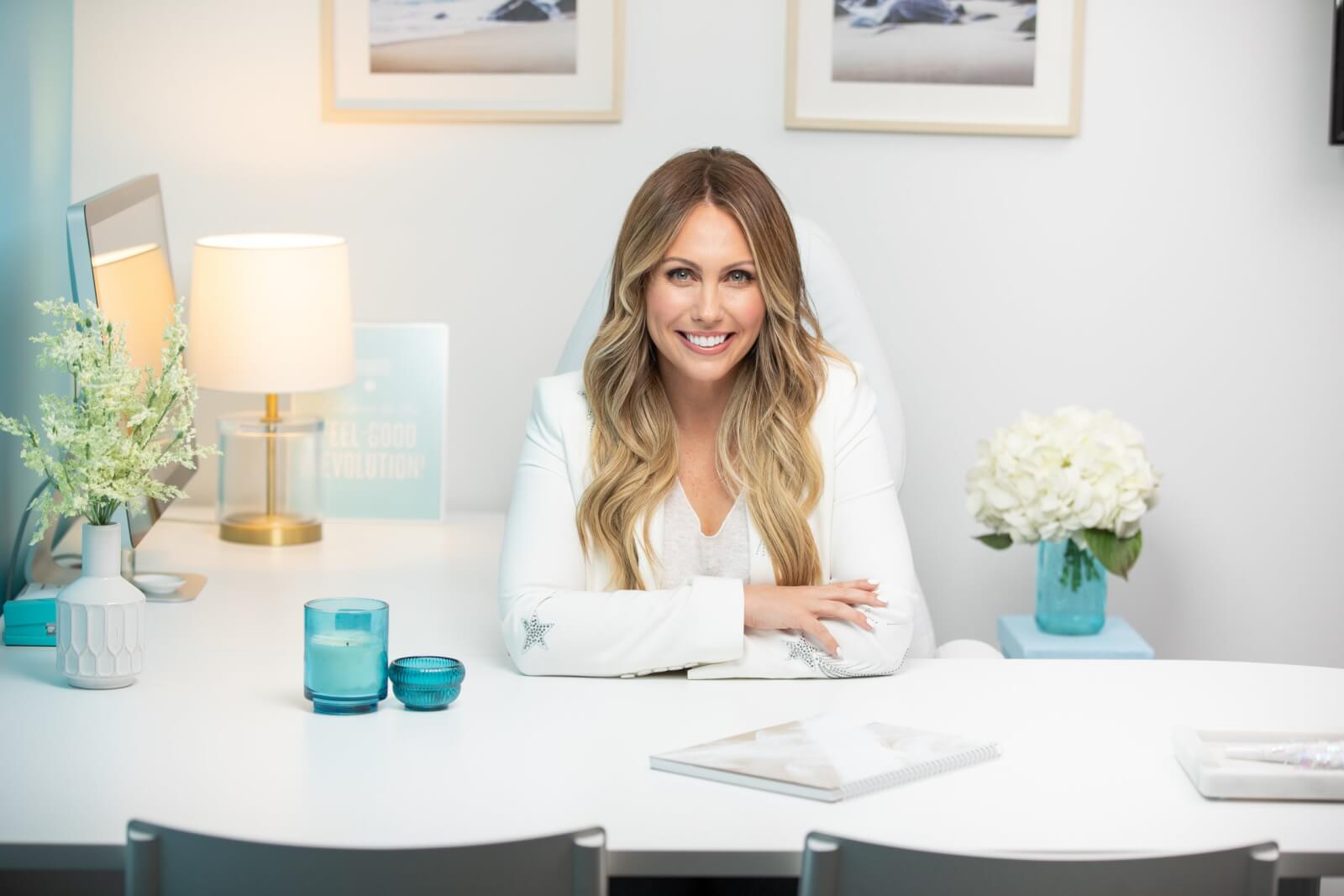 Brittany Driscoll sitting at a desk with blue candles.